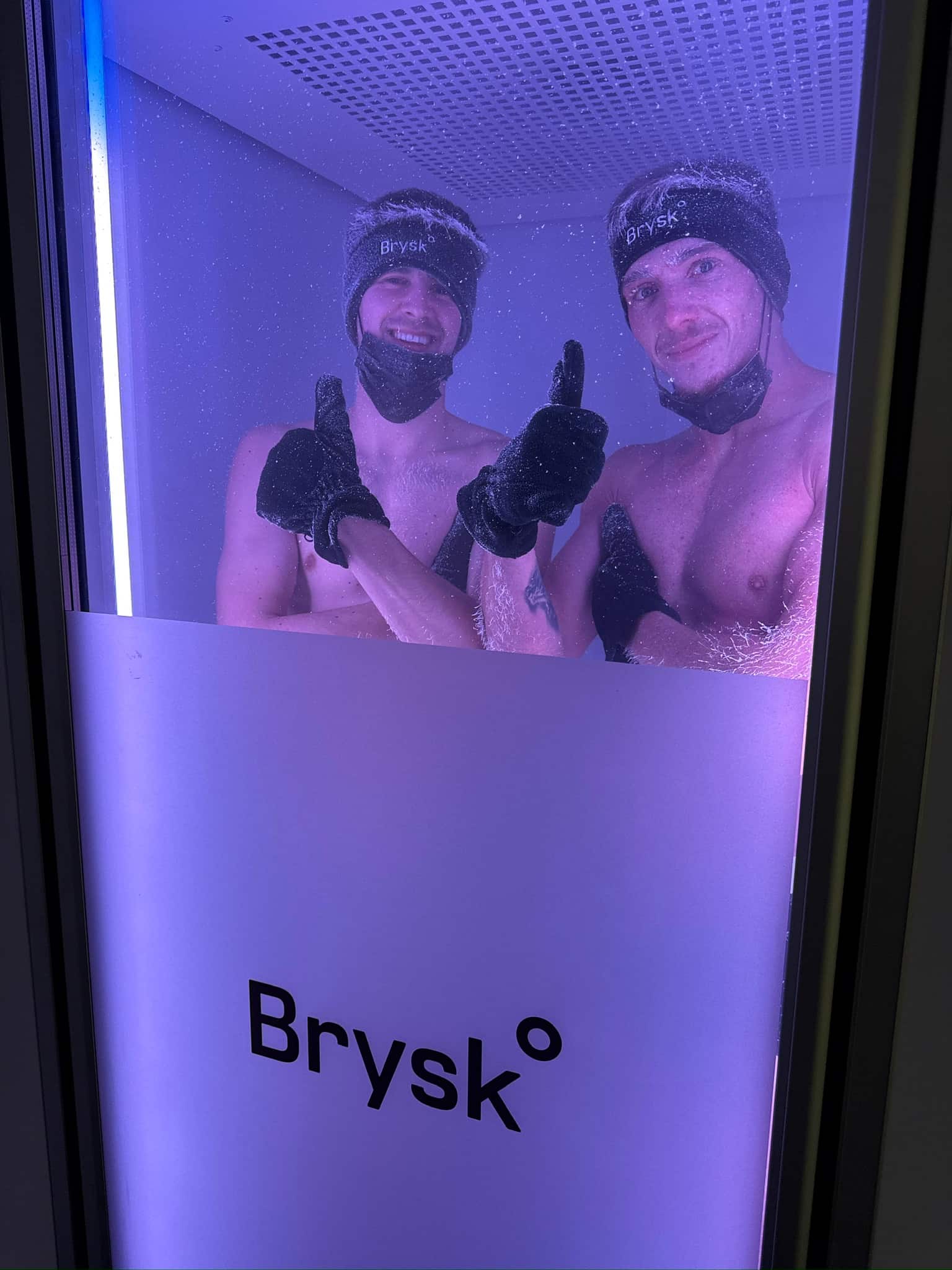 Two clients giving thumbs up during a whole body cryotherapy session at Brysk in Manchester