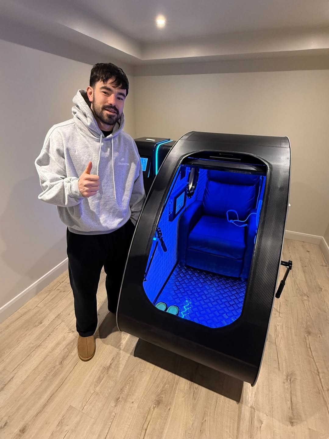 Client standing beside Brysk's hyperbaric oxygen chamber in Manchester